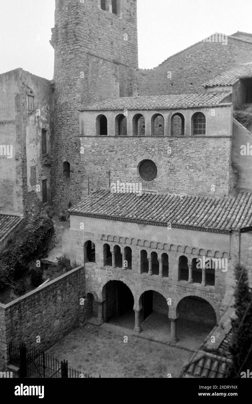 DAS Kloster von San Felíu de Guixols ist bekannt für die porta Ferrada, die den ältesten Teil der Fassade darstellt und aus präromanischer Zeit stammt, und die weiteren Bereiche, die im Laufe der Jahrhunderte gebaut wurden, wie der Turm Torre de Fum mit einem semizirkulären Fundament, der zu den Resten der Festung aus dem 13 Jahrhundert gehört, Katalonien 1957. Il monastero di San Felíu de Guixols è noto per la porta Ferrada, che è la parte più antica della facciata e risale al periodo pre-romanico, e per le altre aree che sono state costruite nel corso dei secoli, come la Torre de Fum towe Foto Stock