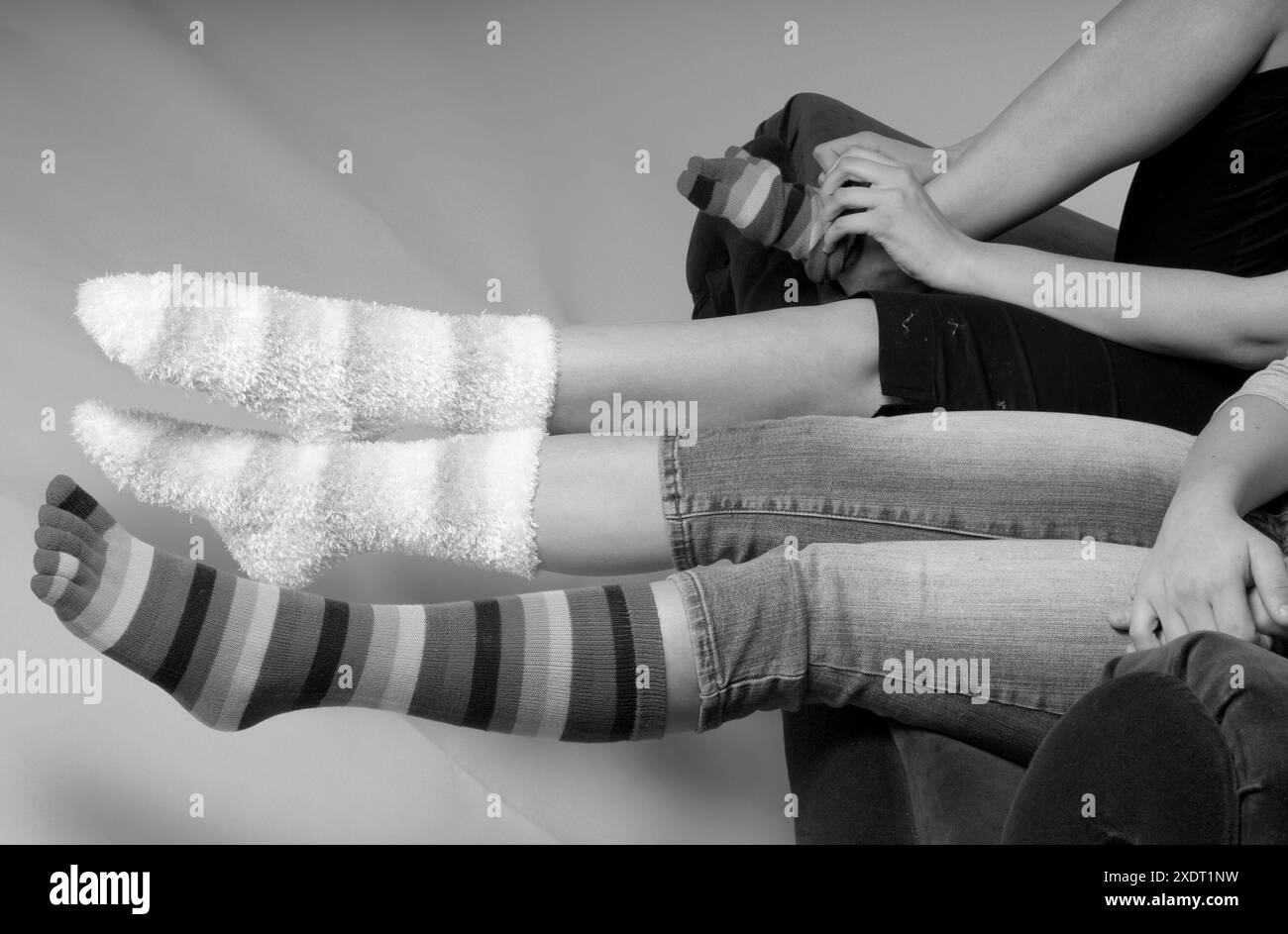 Calzini divertenti e disomogenei sui piedi delle adolescenti, che mettono in mostra le tendenze di moda divertenti e colorate. STATI UNITI Foto Stock