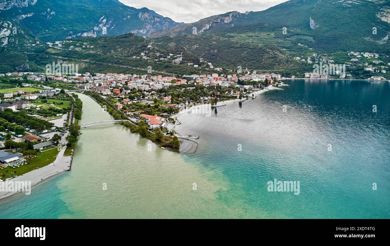 Nago Torbole, Garda, Italia - 24 giugno 2024: L'acqua fluisce dal fiume Sarca al Lago di Garda nella località di villeggiatura settentrionale di Torbole dopo persistenti piogge e tempeste. Il lago ha un alto livello d'acqua il lago ha un alto livello d'acqua. Veduta aerea del fiume Sarca nella città settentrionale di Torbole sul Lago di Garda *** Wassermengen fließen im nördlichen Urlaubsort Torbole vom Fluss Sarca nach anhaltenden Regenfällen und Unwetter in den Gardasee. Vedi HAT hohen Pegelstand. Luftaufnahme vom Fluss Sarca im nördlichen Ort Torbole am Gardasee Foto Stock