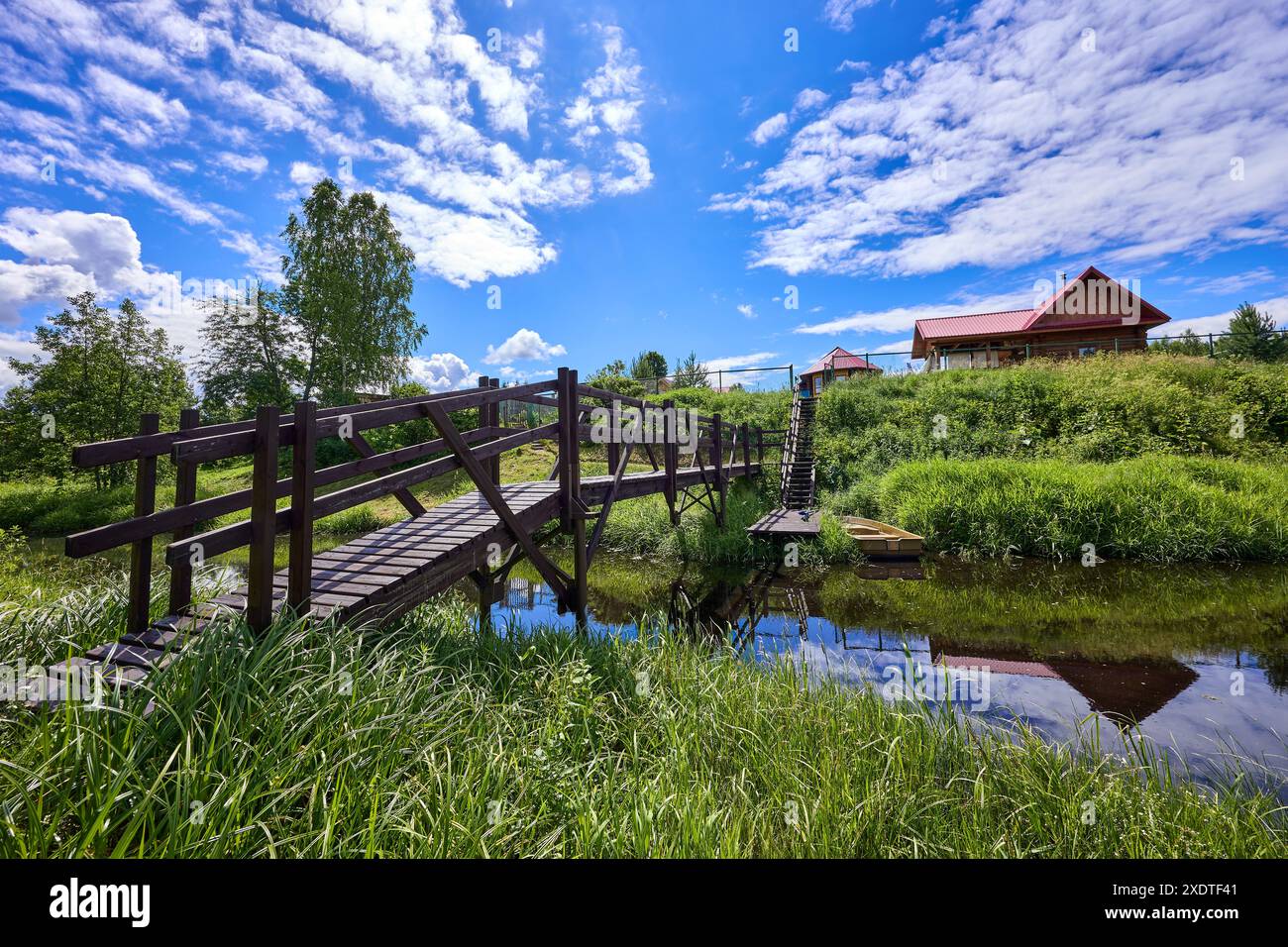 Paesaggio colorato con un ponte di legno sul fiume nelle giornate di sole Foto Stock