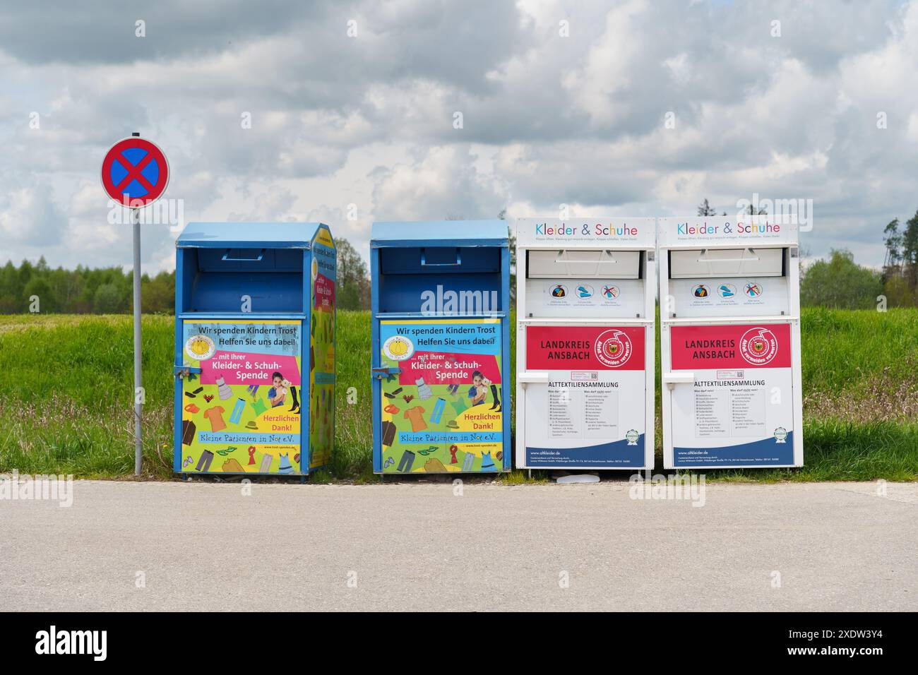 Weinberg, Germania - 2 maggio 2023: Quattro bidoni blu e bianchi per l'abbigliamento dei bambini sono allineati davanti a un campo erboso. Foto Stock