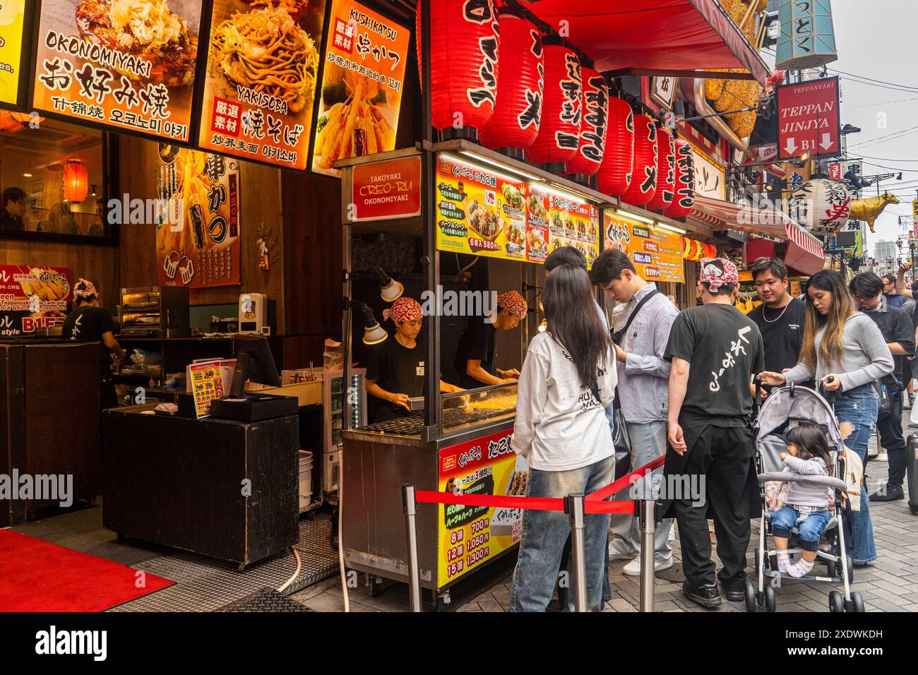 Osaka Giappone, gente che mangia cibo di strada Foto Stock