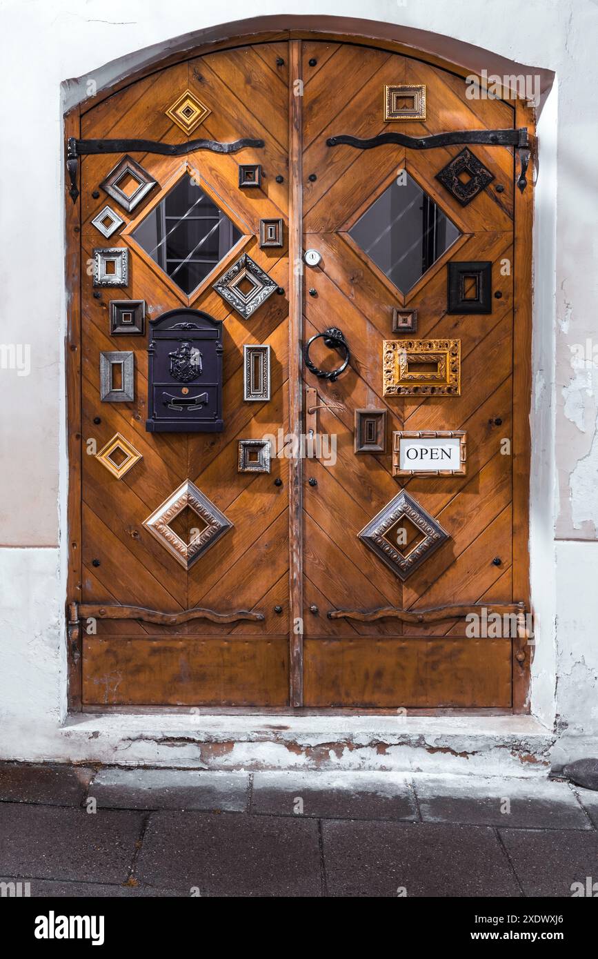 Cornici per foto appese all'edificio della città vecchia, cancelli di legno chiusi Foto Stock