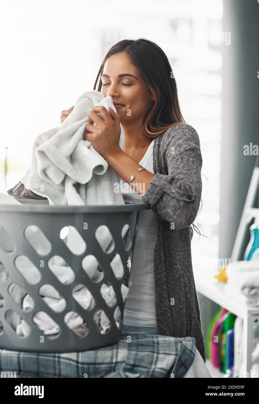 Donna, puzza e cestello per asciugamani in casa, igiene e biancheria fresca o aroma pulito. Donna, respirazione e lavori domestici la mattina Foto Stock