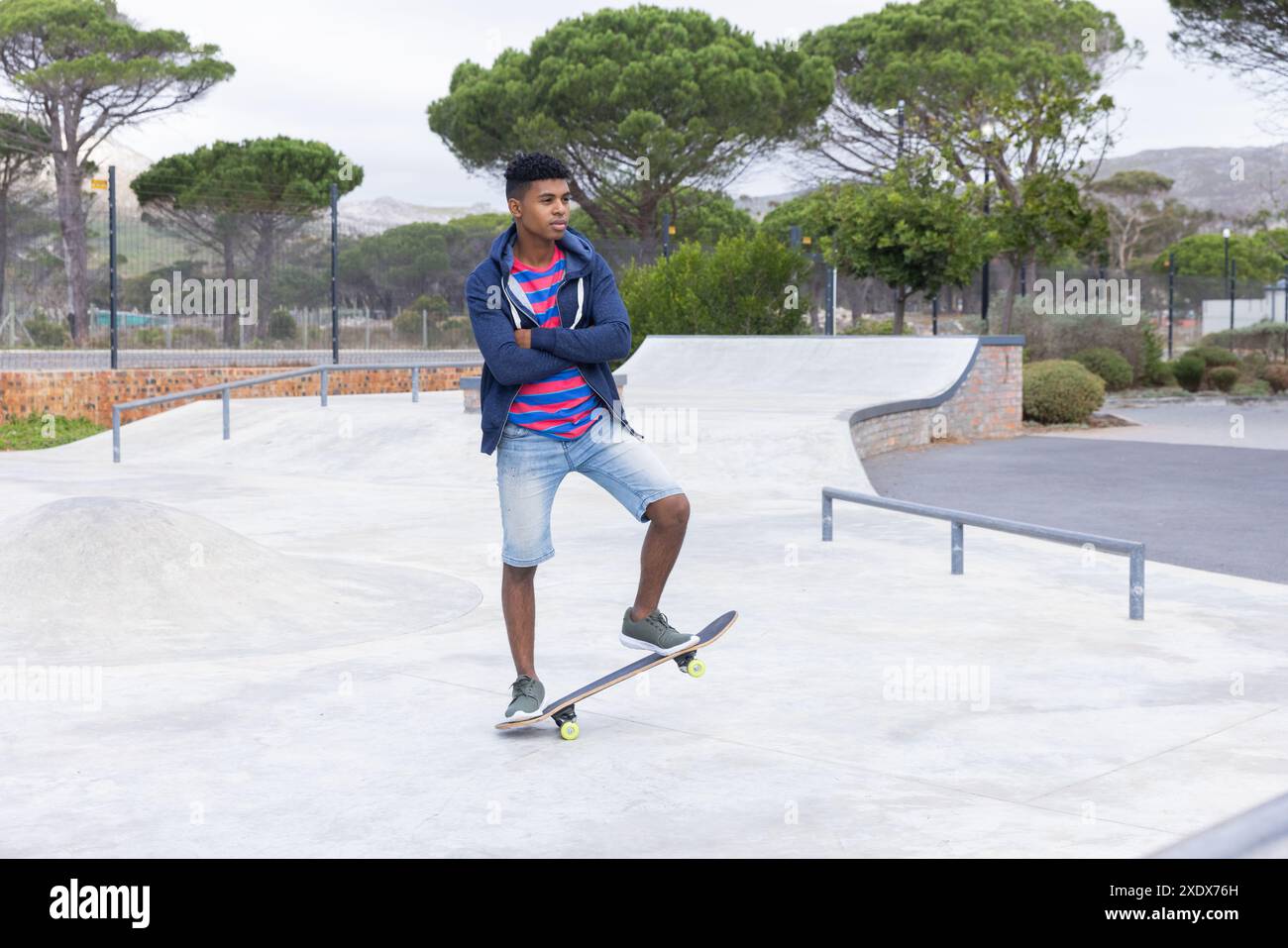 Skateboard nel parco, ragazzo adolescente in piedi sullo skateboard, godendo di attività all'aperto Foto Stock