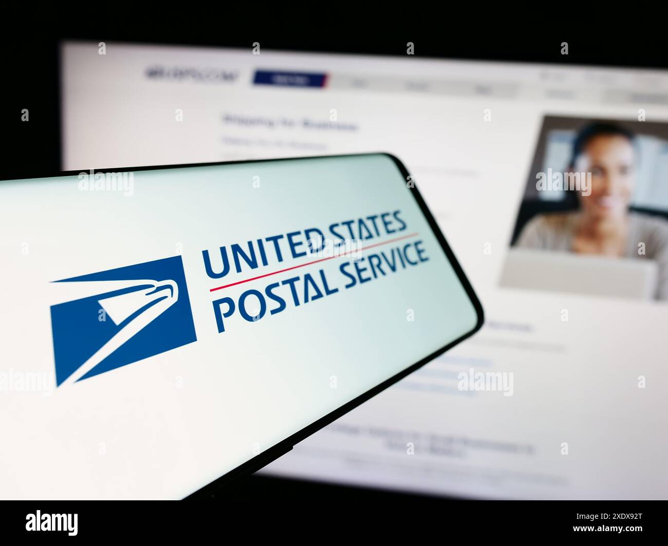 Cellulare con logo dell'agenzia americana United States Postal Service (USPS) davanti al sito web. Mettere a fuoco la parte sinistra del display del telefono. Foto Stock