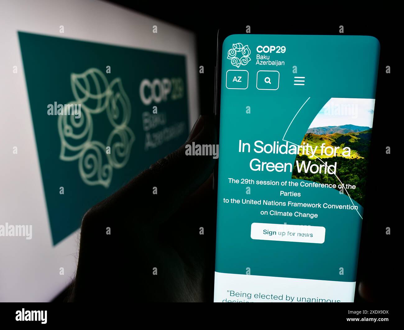 Persona che possiede uno smartphone con la pagina web della Conferenza delle Nazioni Unite sui cambiamenti climatici 2024 COP29 davanti al logo. Messa a fuoco al centro del display del telefono. Foto Stock