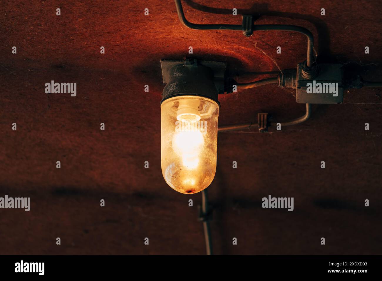 Vecchia lampadina da soffitto nel capannone, messa a fuoco selettiva Foto Stock