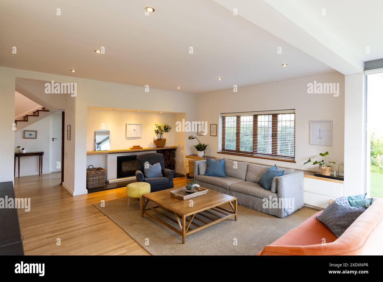 Soggiorno moderno con comodi posti a sedere, tavolino da caffè in legno, grandi finestre, spazio fotocopie Foto Stock