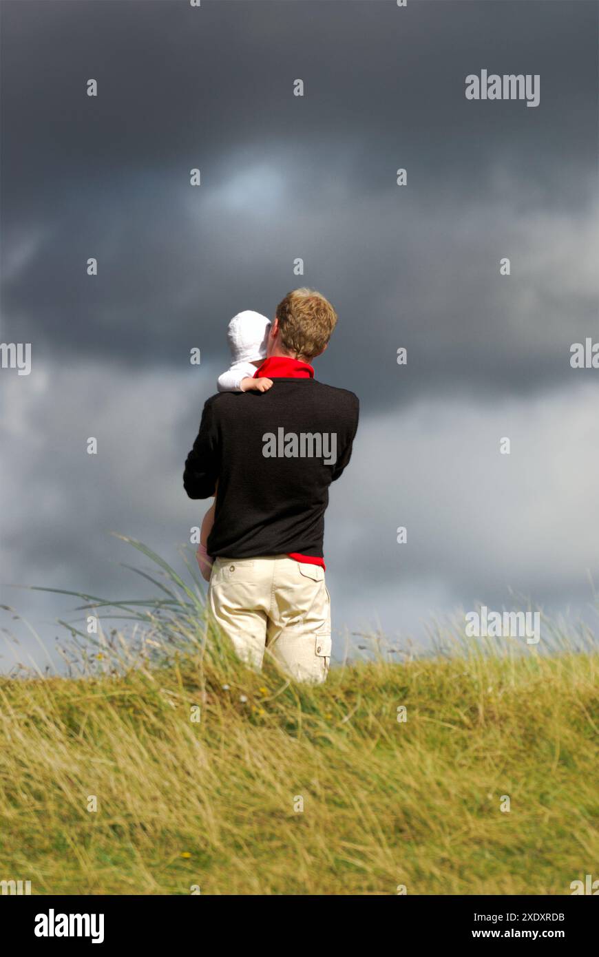 Un padre porta suo figlio su una duna Foto Stock
