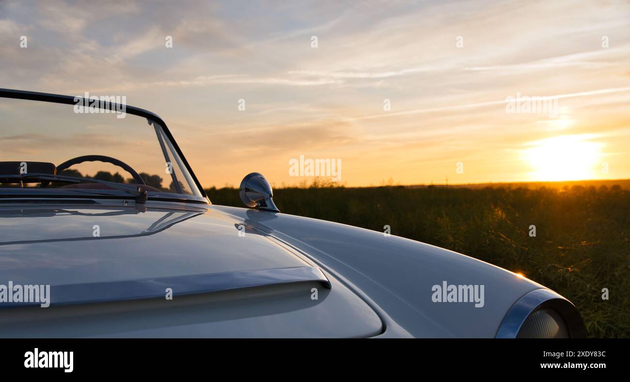 Fiat 1500 auto d'epoca in un bellissimo tramonto vicino a un campo di mais Foto Stock