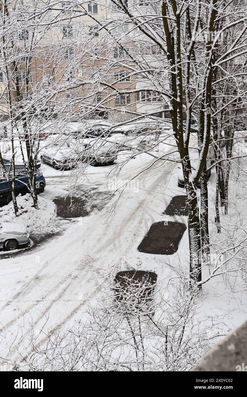 Tracce scure di auto sulla strada innevata Foto Stock