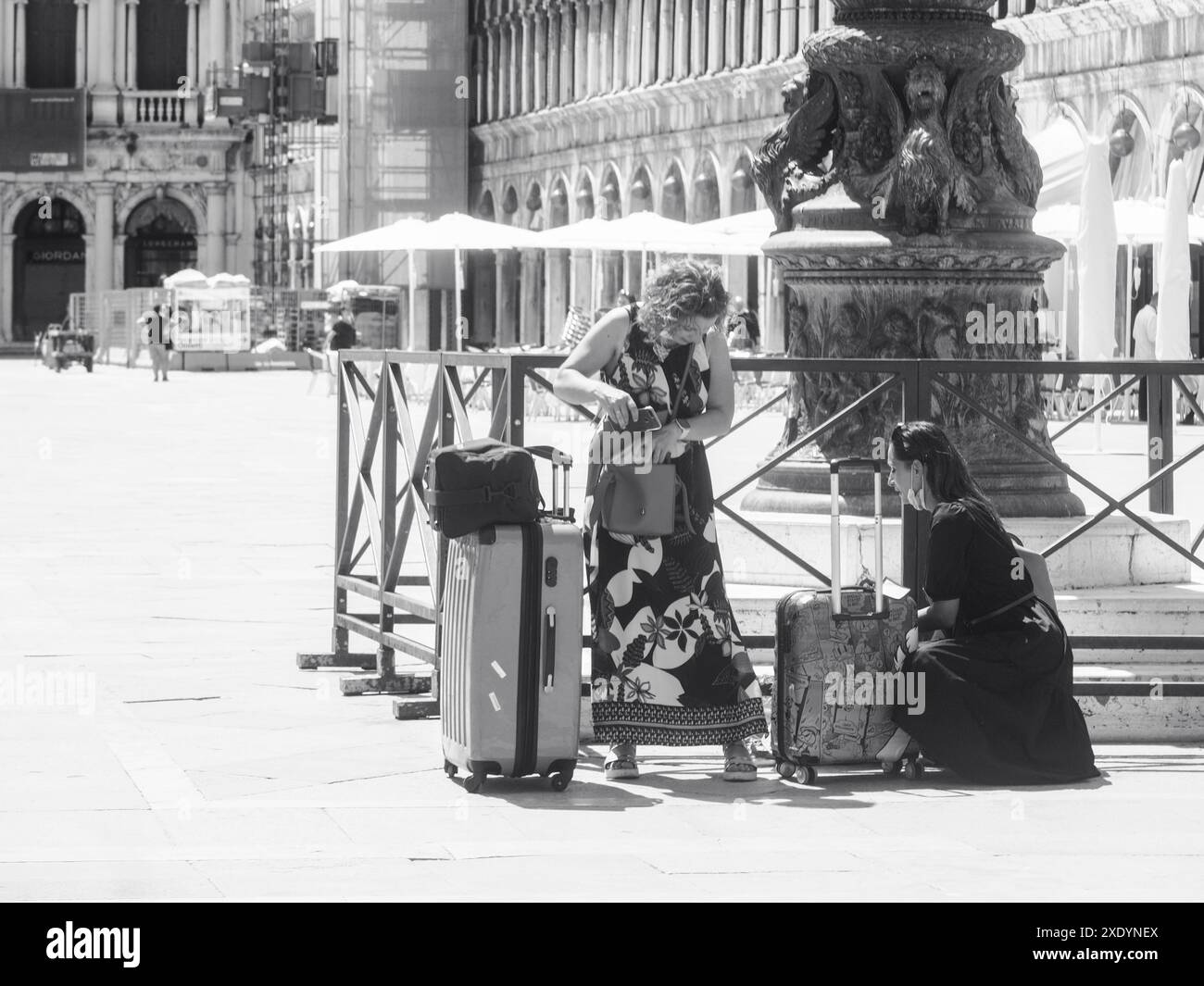 Venezia, Italia - 30 giugno 20220 due donne turisti stanno controllando i loro bagagli in una piazza deserta a venezia, italia Foto Stock