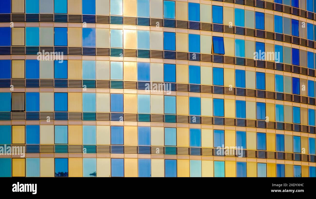 Edificio moderno con facciata in vetro. Colori dorati brillanti. Immagine di sfondo Foto Stock