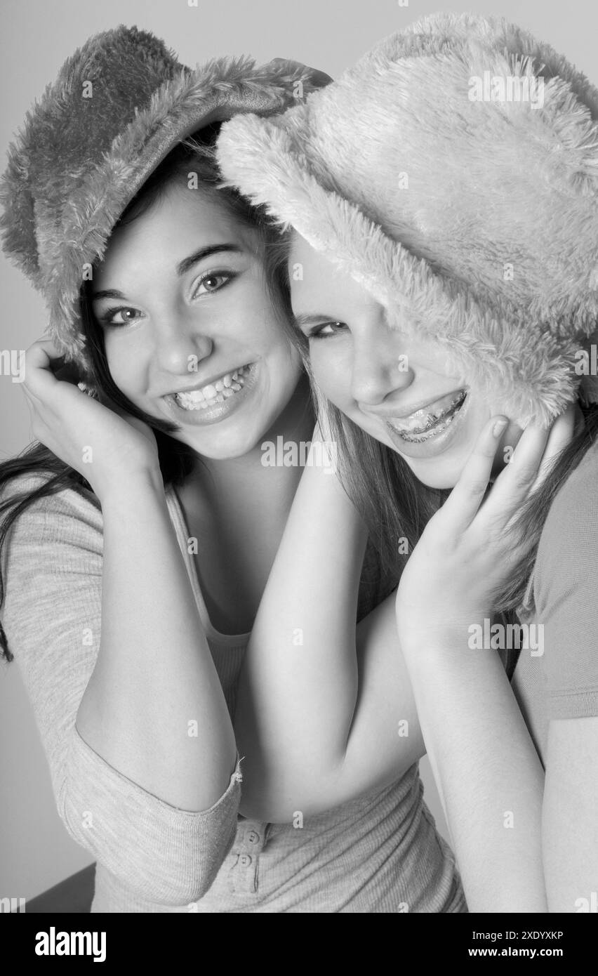 Due ragazze caucasiche che indossano cappelli colorati e sorridono. STATI UNITI Foto Stock