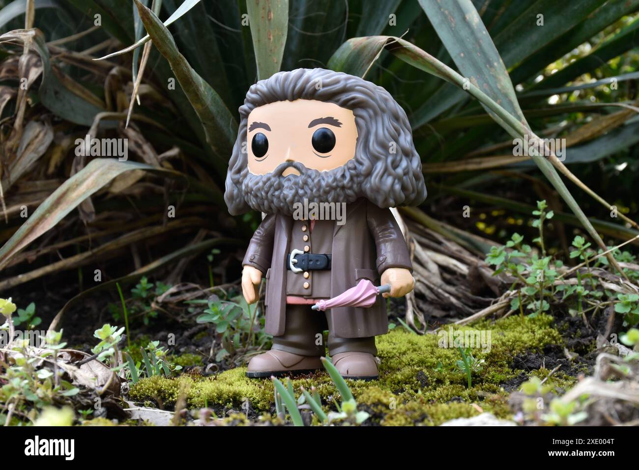 Funko Pop action figure del guardiano Hagrid mezzo gigante con ombrello del film fantasy Harry Potter. Foresta favolosa, muschio, piante, foglie, erba. Foto Stock