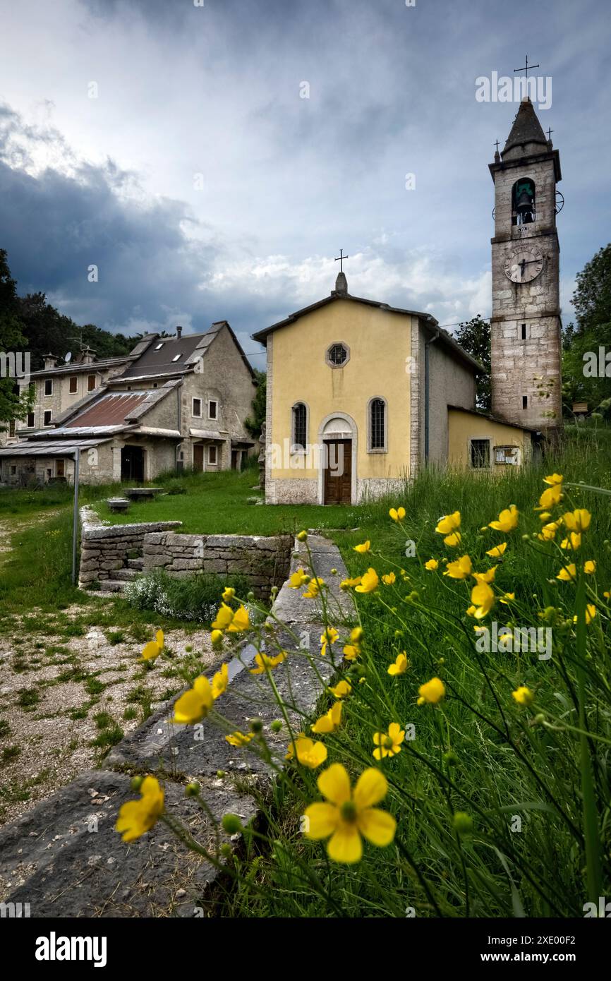 Frazione di Camposilvano: La chiesa di San Carlo Borromeo e antiche case in architettura cimbra. Velo Veronese, Lessinia, Veneto, Italia. Foto Stock