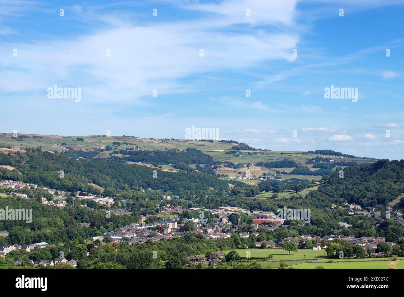 Vista panoramica del villaggio o mitolmroyd di calderdale, yorkshire occidentale, circondato da alberi e prati estivi Foto Stock