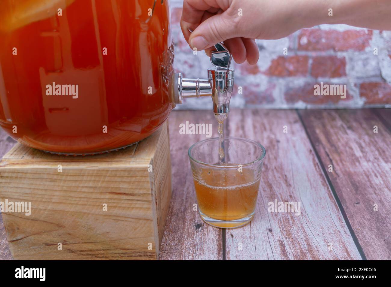 Aprire il rubinetto di una bottiglia di tè kombucha fermentato Foto Stock