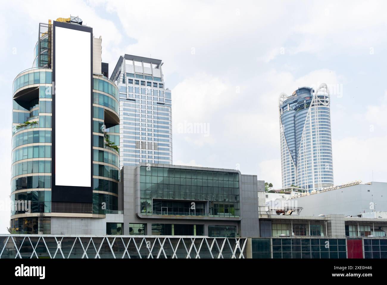 Grande cartellone bianco sul lato di un edificio a Bangkok, Thailandia. Billboard si trova in una trafficata area commerciale ed è circondato da altri alti b Foto Stock