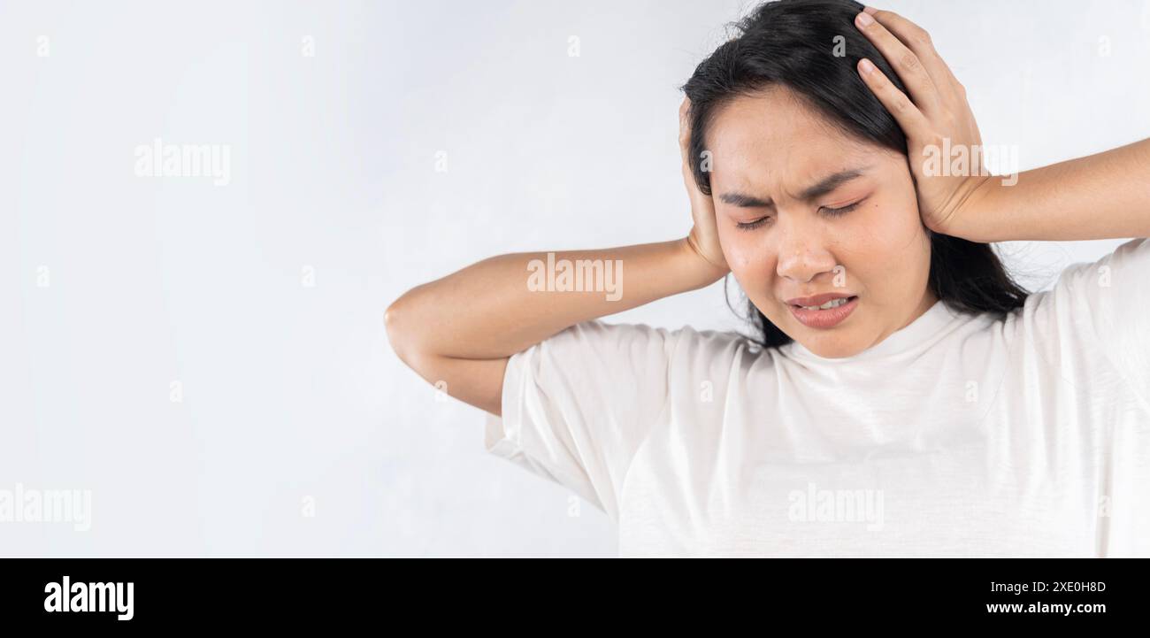 Concetto di tinnito. Primo piano profilo laterale una giovane donna malata che soffre di dolore alle orecchie che le toccano la testa dolorosa isolata su sfondo bianco. Foto Stock