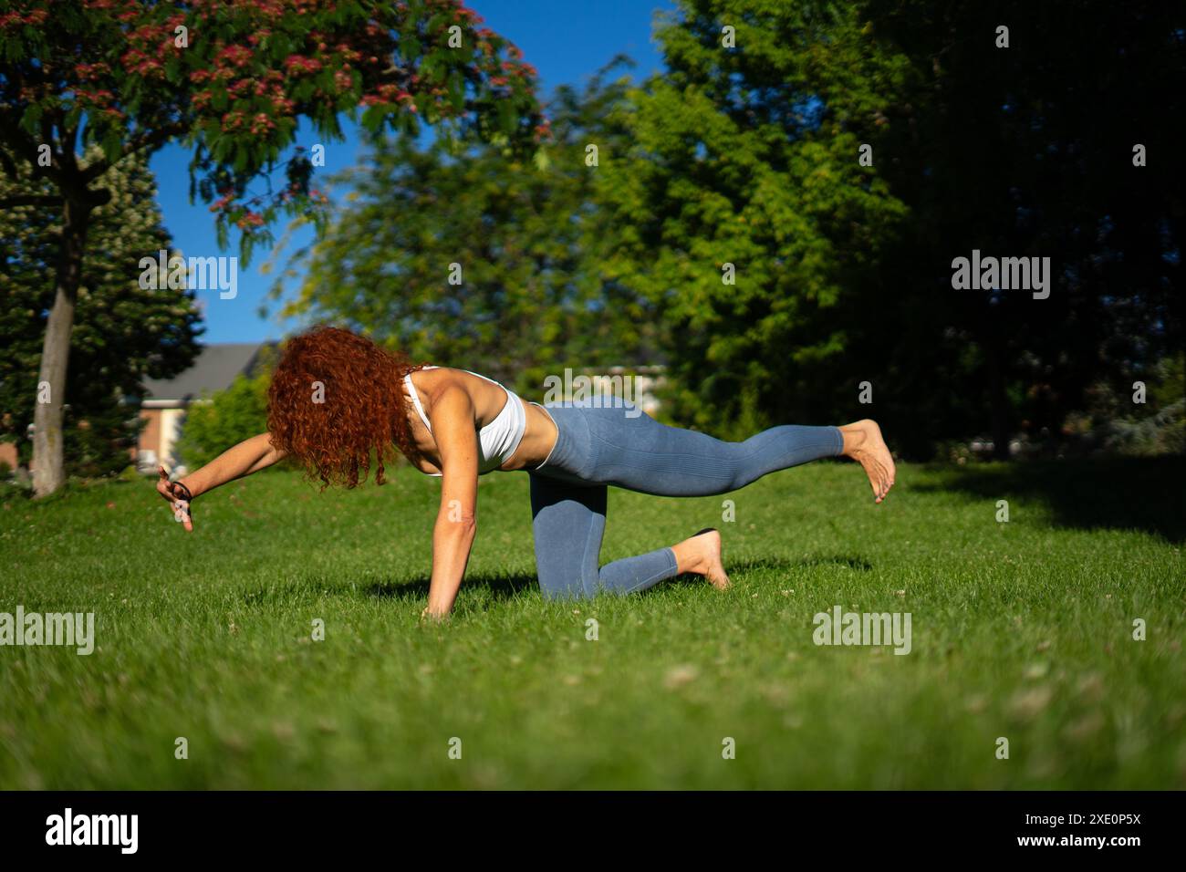 Donna che fa pilates posare in un parco all'aperto. Stile di vita sano. La salute delle donne. pavimento pelvico Foto Stock