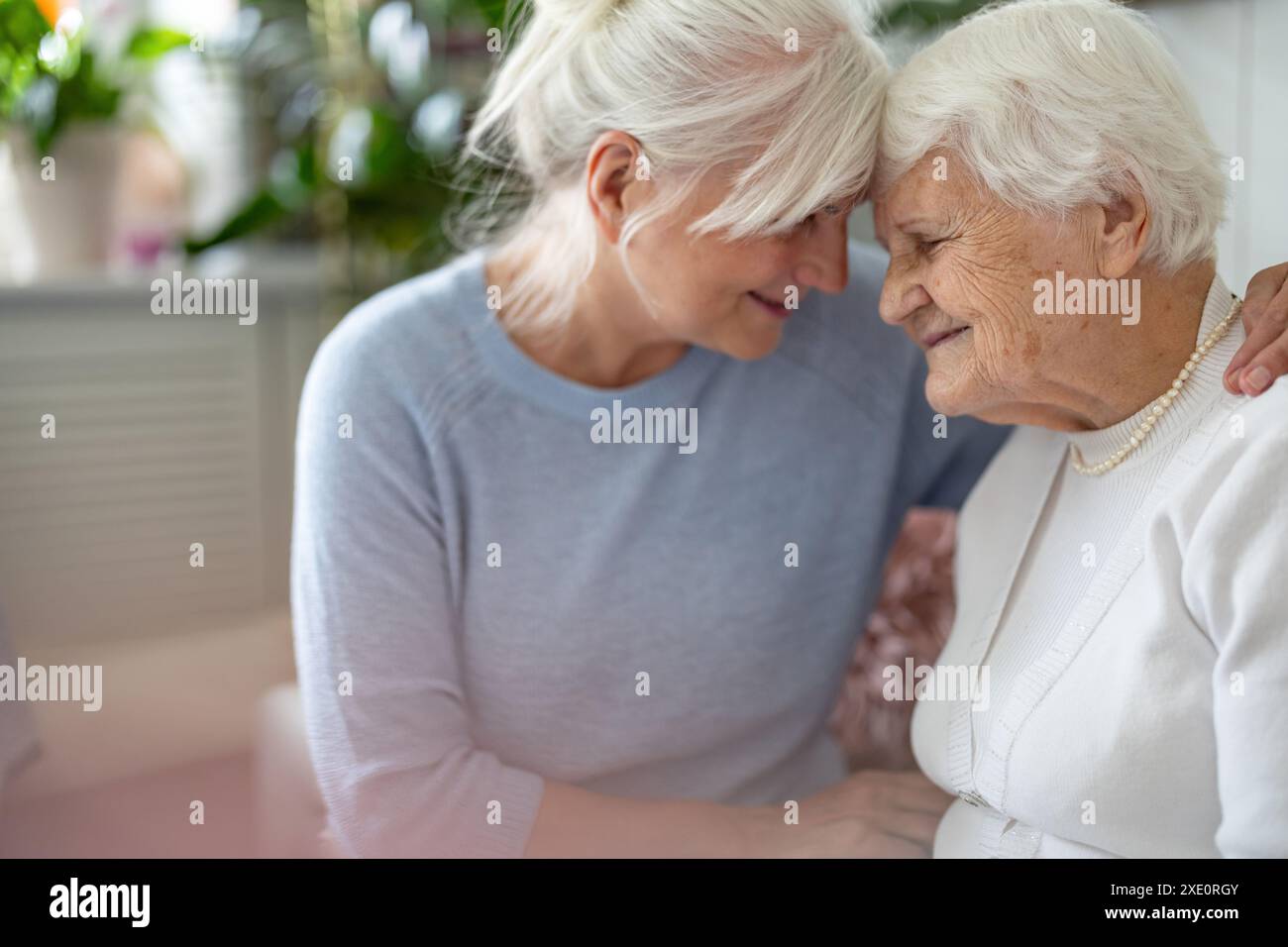 Felice donna anziana con sua figlia adulta a casa Foto Stock