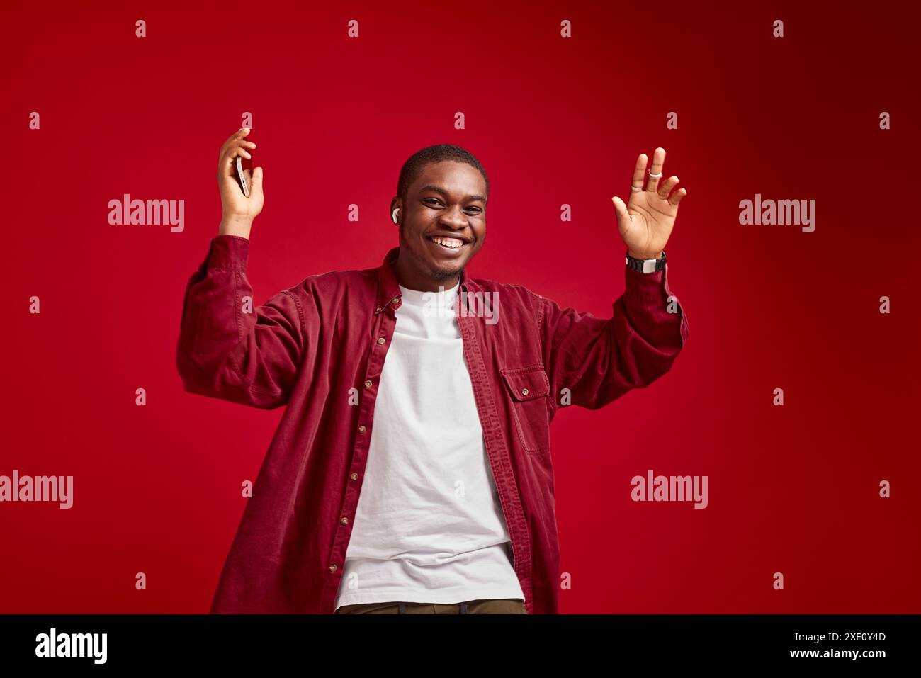 Uomo emotivo di aspetto africano con un telefono in mano, tecnologia di comunicazione, gioia e successo Foto Stock