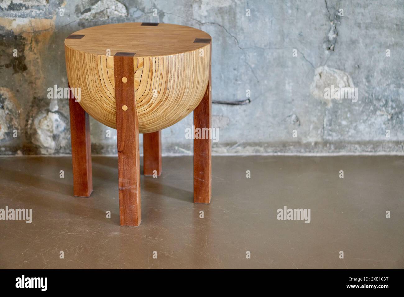panca in legno rustico e circolare con parete posteriore in marmo all'interno di una cantina. Foto Stock
