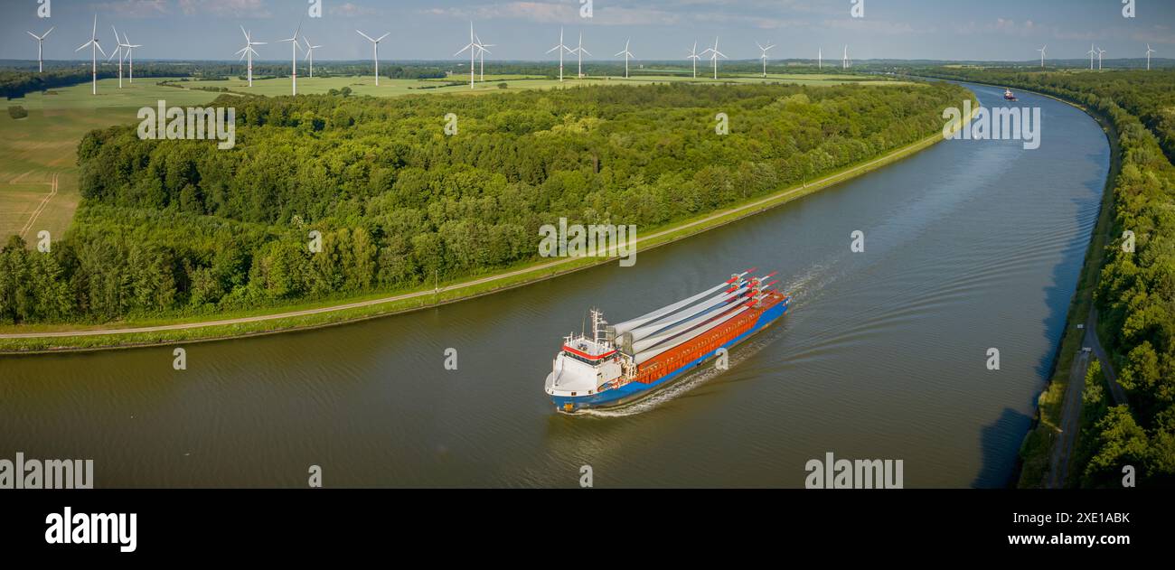 La nave da carico che trasporta pale di turbine eoliche sta navigando attraverso il Canale di Kiel con un parco eolico nel Foto Stock