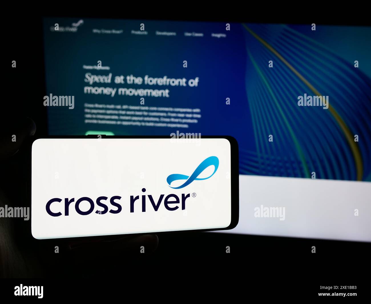 Persona che possiede uno smartphone con il logo della società statunitense di servizi finanziari Cross River Bank davanti al sito Web. Mettere a fuoco il display del telefono. Foto Stock
