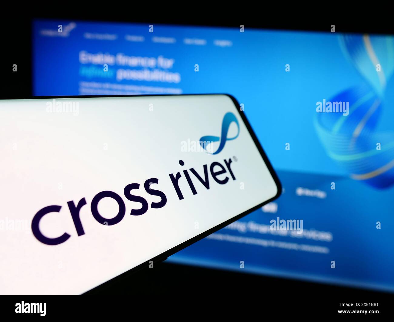 Telefono cellulare con logo della società americana di servizi finanziari Cross River Bank davanti al sito Web aziendale. Messa a fuoco al centro del display del telefono. Foto Stock