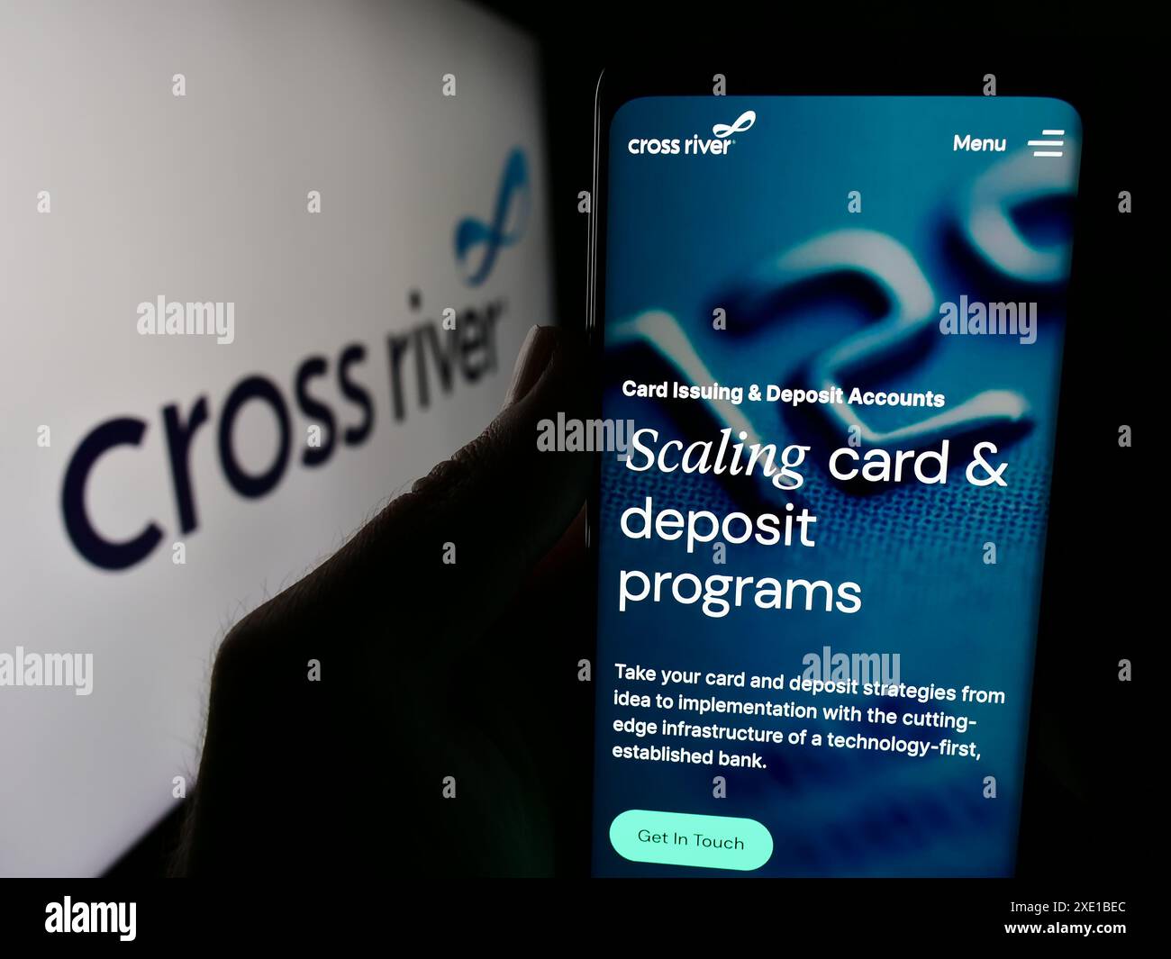 Persona che possiede uno smartphone con la pagina web della società statunitense di servizi finanziari Cross River Bank davanti al logo. Messa a fuoco al centro del display del telefono. Foto Stock