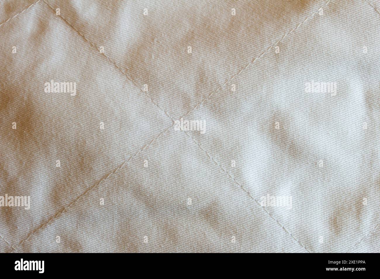Primo piano di un tessuto trapuntato realizzato in cotone con un motivo a diamante meticolosamente lavorato e cuciture uniformi che mostrano uno scolorimento naturale Foto Stock