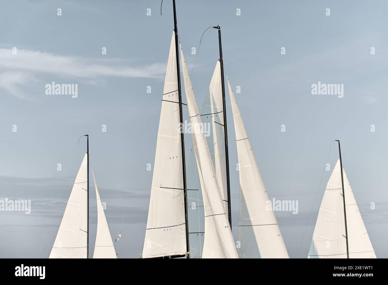 Le cime di diverse vele sono illuminate dal sole al tramonto, dal cielo limpido e dai montanti Foto Stock Le cime di diverse vele sono illuminate dal sole al tramonto, dal cielo limpido e dai montanti Foto Stock