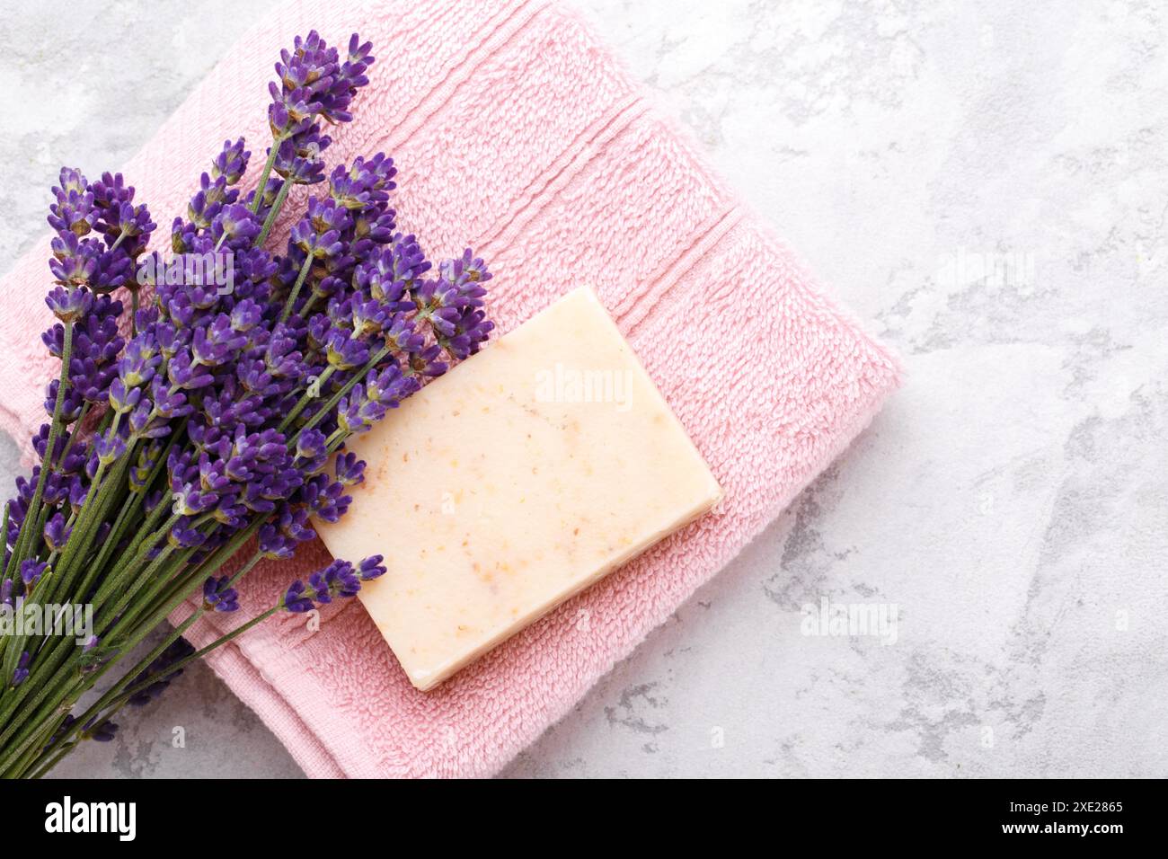 Sapone fatto a mano con fiori di lavanda su fondo in pietra grigia, con spazio di copia Foto Stock