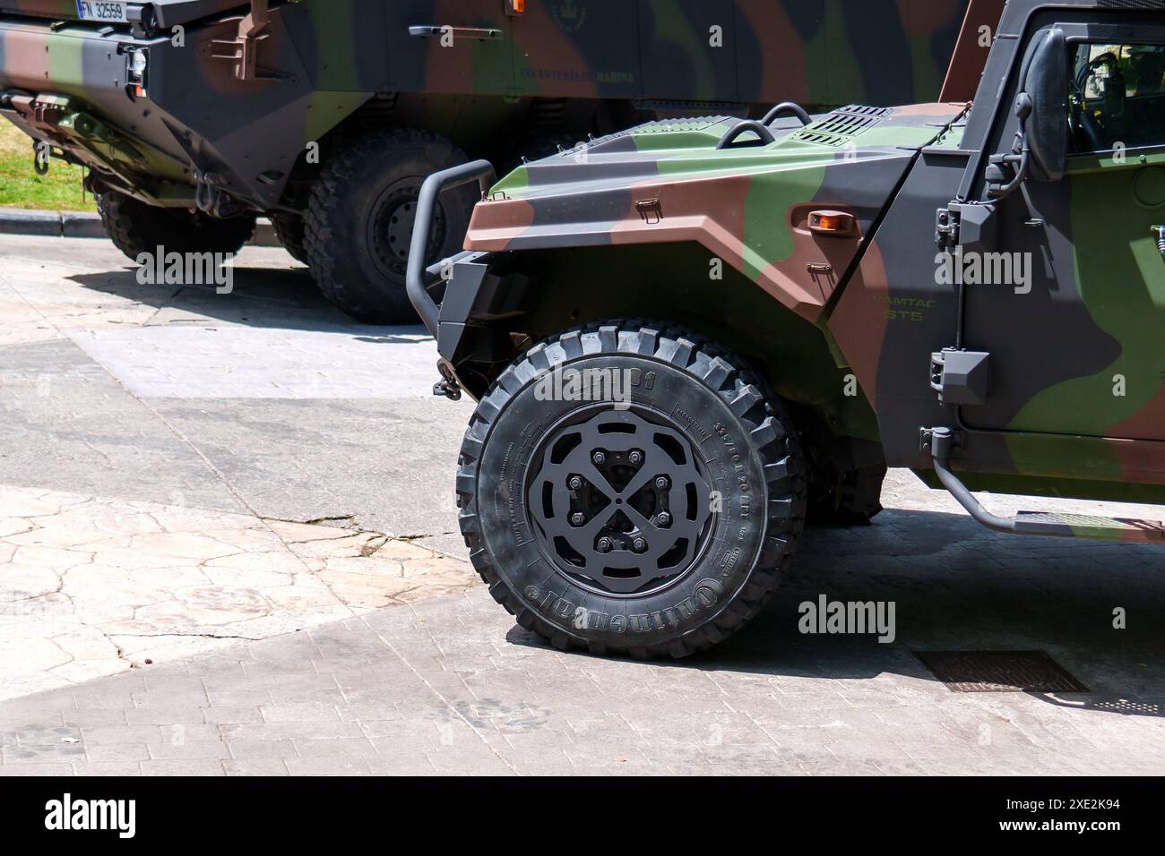 Oviedo, Spagna - 25 maggio 2024: Veicolo militare con vernice mimetica parcheggiato sul marciapiede alla luce del giorno con grandi pneumatici Continental e un gradino che corre a Foto Stock