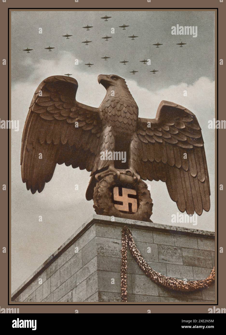 Propaganda nazista: REICHEAGLE: 1938, Aquila Nazionale su una base nella Luitpold Arena, Norimberga Germania nazista. REICHSAdler: 1938, aquila nazionale su una base nella Luitpoldarena, con aerei della Luftwaffe che volano indietro in uno spettacolo di forza nazista, dominazione e prontezza alla guerra Foto Stock