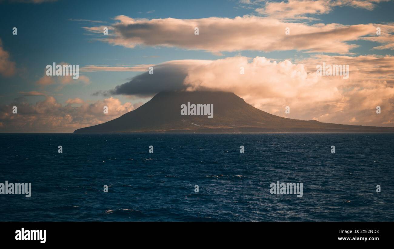 Paesaggio montano, Isola di Saba, parte dei Caraibi olandesi. Colpo lontano mentre il sole tramonta dietro il vulcano. Foto Stock
