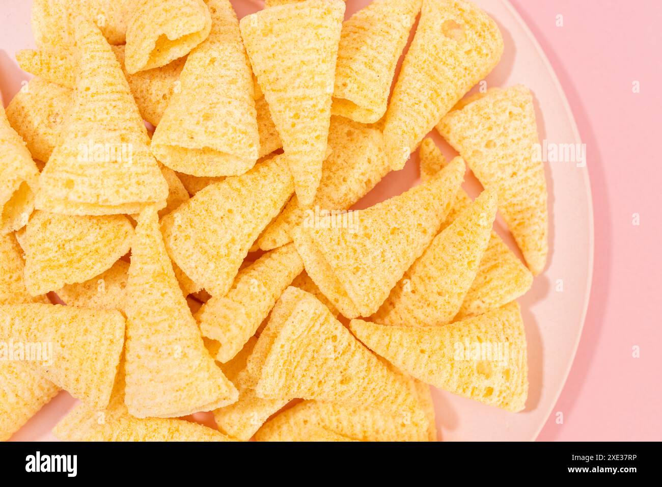 Primo piano dello spuntino Cone Corn sul piatto su sfondo rosa Foto Stock