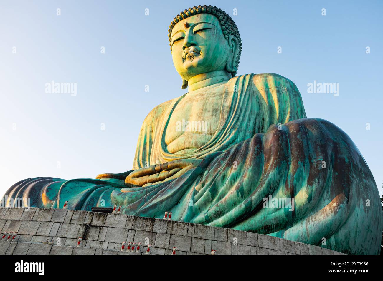 Vista dall'angolo basso della grande statua del Buddha seduto sulla cima della montagna. Foto Stock