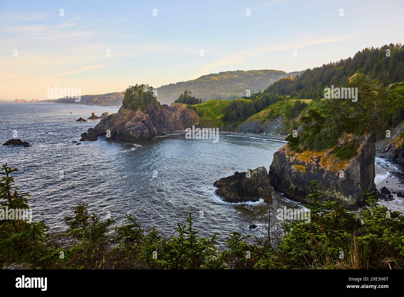 Scogliere aspre e calmo Cove a Golden Hour da High Vantage Point Foto Stock