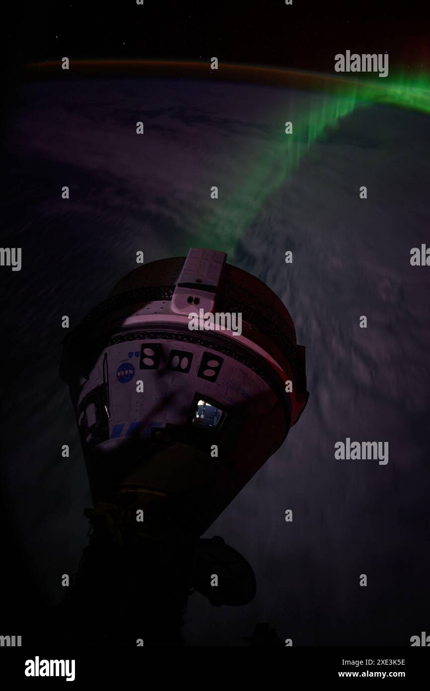 In questa foto, un'aurora scorre sotto la navicella spaziale Starliner della Boeing attraccata al porto anteriore sul modulo Harmony mentre la stazione spaziale Internazionale sorvolava 266 miglia sopra l'Oceano Indiano a sud-ovest dell'Australia. Le squadre della NASA e della Boeing stanno adeguando il ritorno sulla Terra della navicella Starliner Crew Flight test con gli astronauti Butch Wilmore e Suni Williams della stazione spaziale Internazionale. Lo spostamento di mercoledì 26 giugno sconvolge lo sgancio e l'atterraggio di Starliner da una serie di passeggiate spaziali della stazione spaziale Internazionale previste lunedì 24 giugno e martedì, luglio Foto Stock