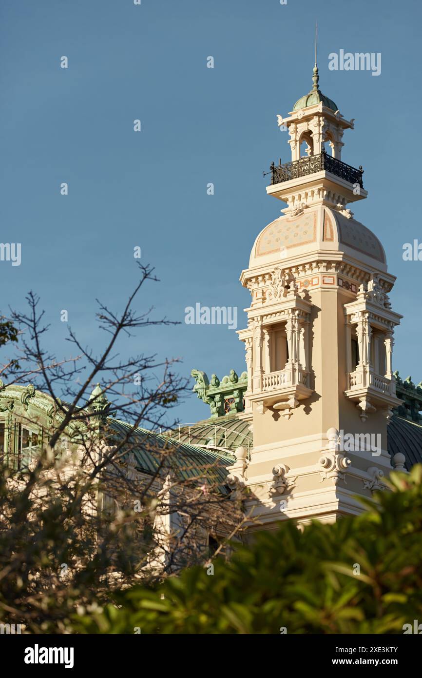 Monaco, Monte-Carlo, 21 ottobre 2022: Torre del Casinò Monte-Carlo al tramonto, vita ricca, famoso punto di riferimento, pini, cielo blu Foto Stock