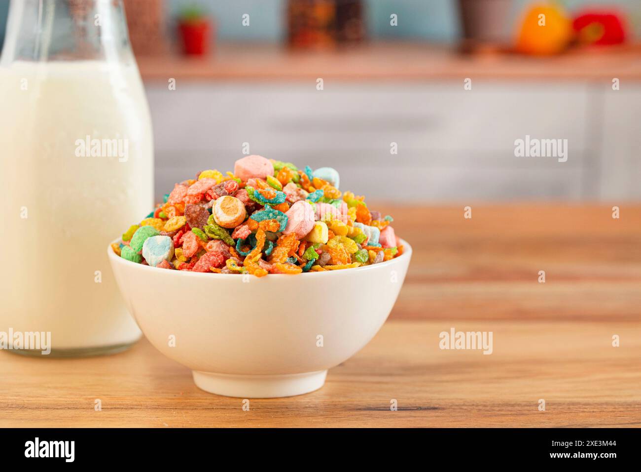 Una ciotola di cereali Marshmallow per bambini arcobaleno aromatizzati ai frutti arcobaleno su un tavolo di legno in cucina Foto Stock