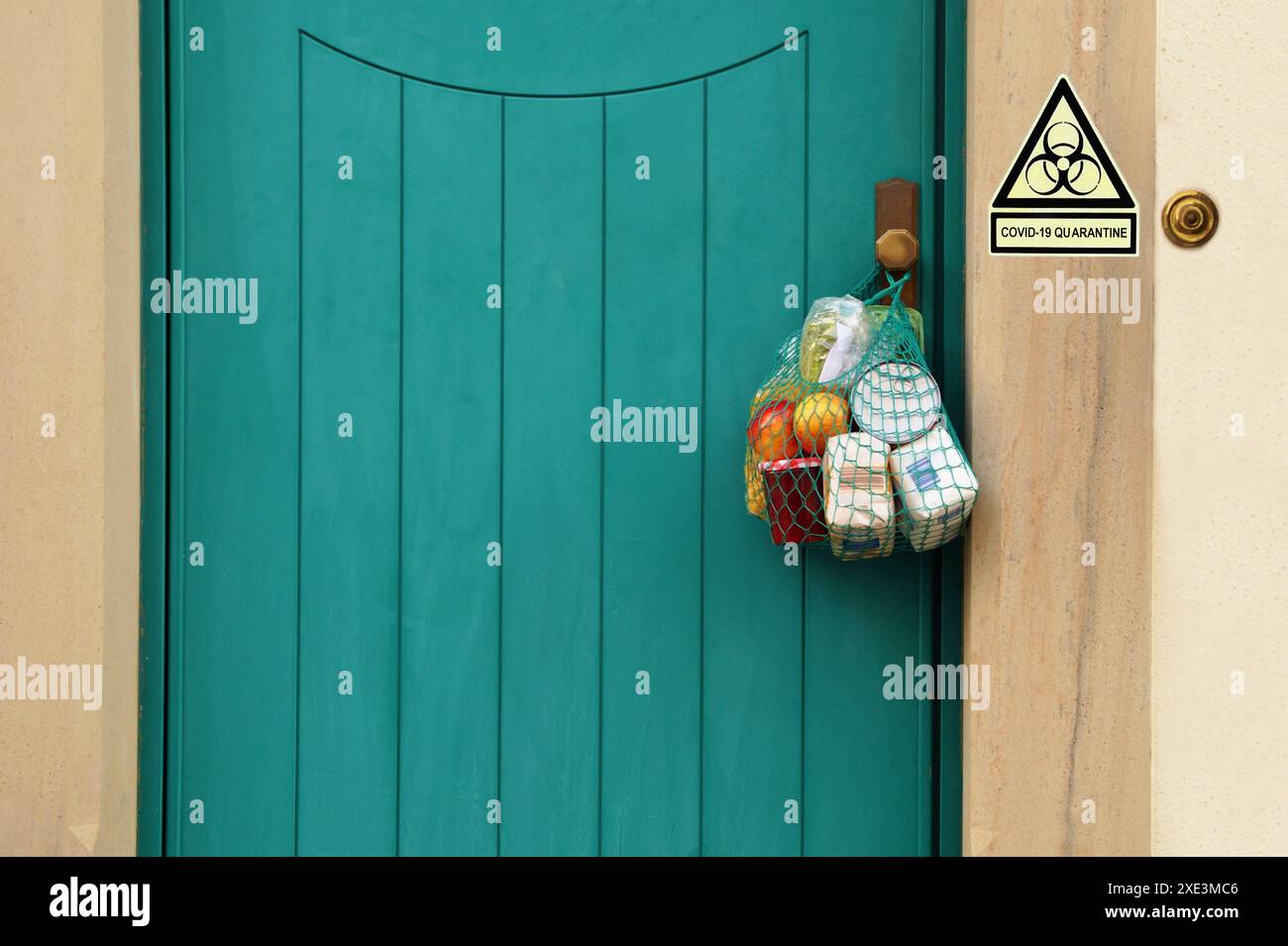 Consegna di cibo durante la quarantena. La borsa della spesa con articoli di merchandising, merci e cibo è appesa al Foto Stock