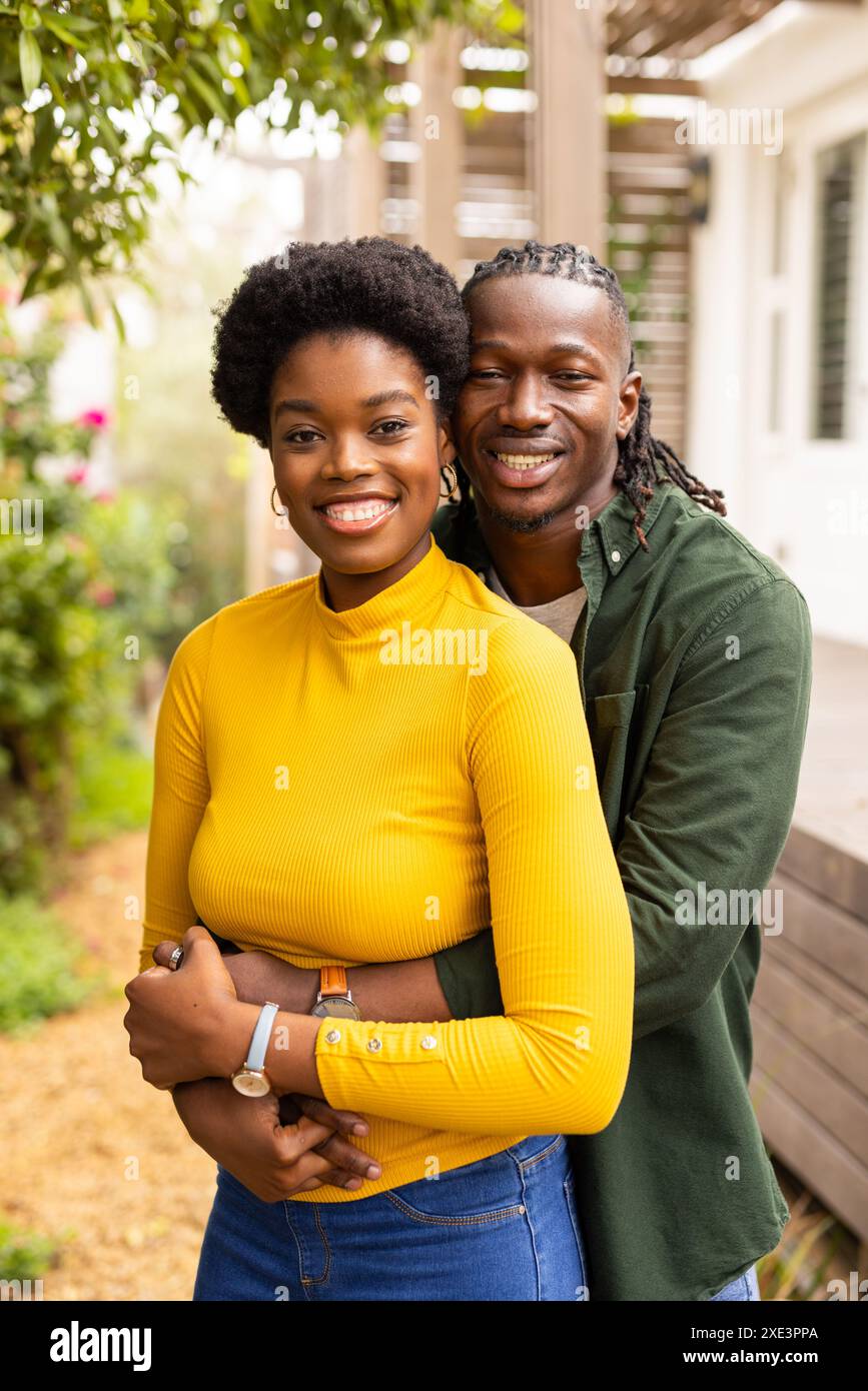 Coppia sorridente che abbraccia l'aria aperta, godendo momenti di qualità insieme a casa Foto Stock