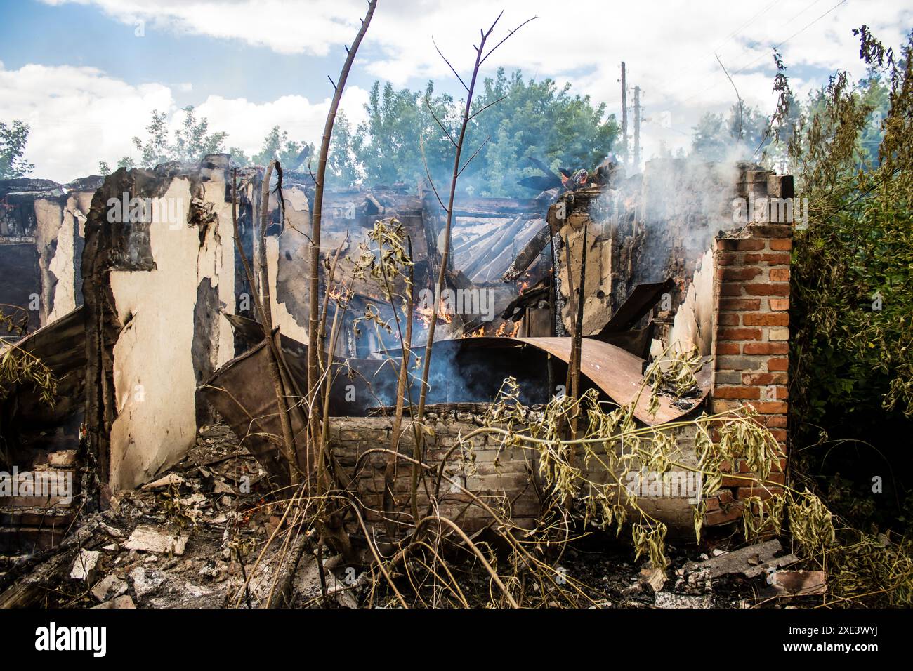 Kupiansk, Ucraina, 24 giugno 2024 Una casa a Kupiansk sta bruciando dopo il fuoco dell'artiglieria. La città fu colpita duramente dagli attacchi russi. Infrastrutture civili Foto Stock