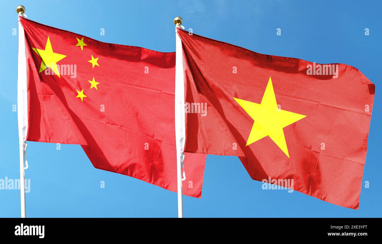 Bandiera cinese e bandiera del Vietnam sul cielo nuvoloso. sventolando nel cielo Foto Stock