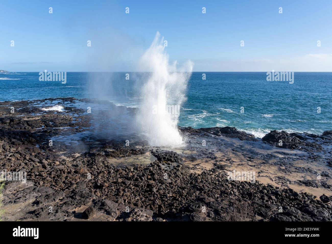 Un blowhole sulla costa sud di Kauai vicino a Poipu, Hawaii, Stati Uniti. Il soffiante spara acqua di mare attraverso il suo tubo di lava naturale fino a 50 metri nell'aria. Foto Stock